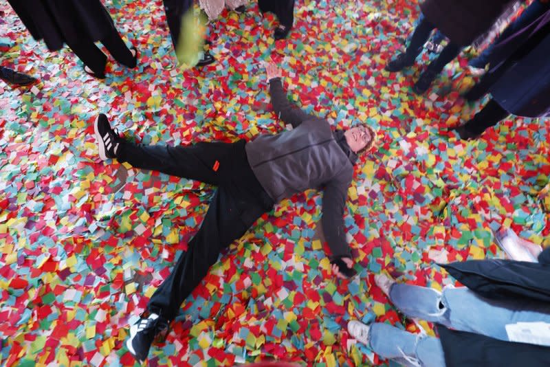 A reveler lays in confetti at midnight in Times Square for the New Year's Eve celebrations in New York City on Monday. Photo by John Angelillo/UPI