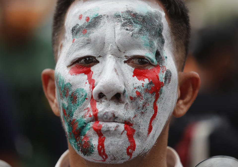 An anti-government protester paints his face blood crying during a protest near Democracy Monument in Bangkok, Thailand, Wednesday, Oct. 14, 2020. Thai activists hope to keep up the momentum in their campaign for democratic change with a third major rally in Bangkok on Wednesday. (AP Photo/Sakchai Lalit)