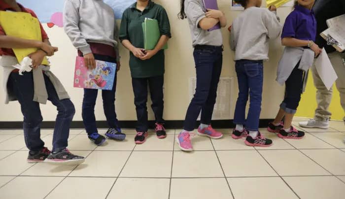 a line of young teenagers standing on linoleum floor