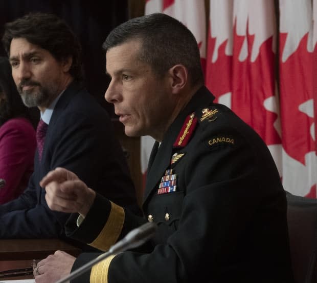 Prime Minister Justin Trudeau listens to Maj.-Gen. Dany Fortin respond to a question during a news conference in Ottawa, Monday, Dec. 7, 2020. Fortin, Canada's former vaccine campaign lead, left the post Friday after an allegation of sexual misconduct was raised. (Adrian Wyld/The Canadian Press - image credit)