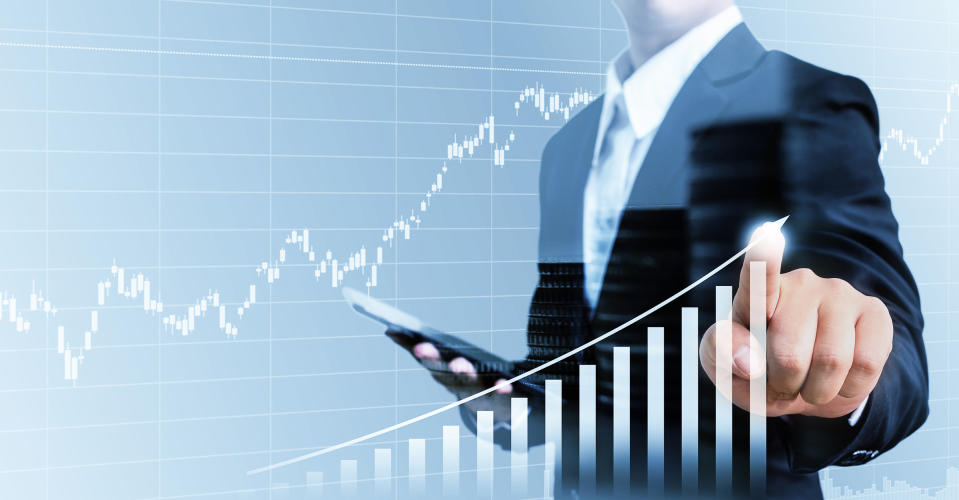 Man's hand touching graph showing a chart doubling