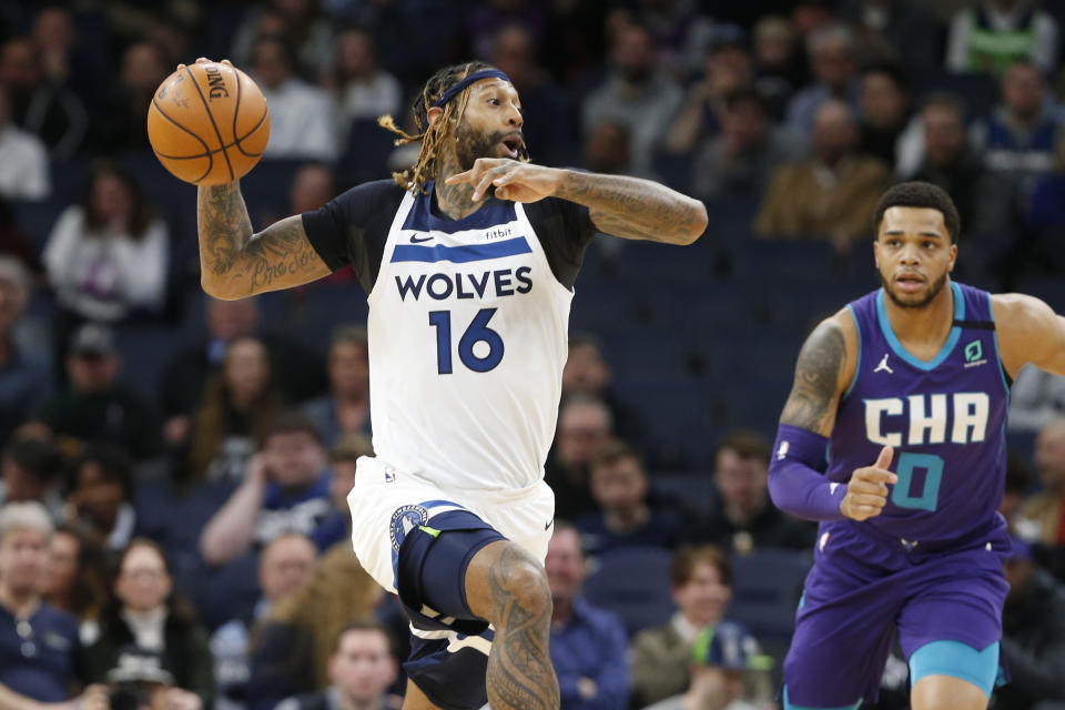 Minnesota Timberwolves' James Johnson, left, looks to pass the ball as Charlotte Hornets' Miles Bridges pursues during the first half of an NBA basketball game Wednesday, Feb. 12, 2020, in Minneapolis. (AP Photo/Jim Mone)