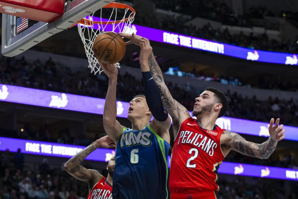 New Orleans Pelicans guard Lonzo Ball (2) blocks a shot attempt from Dallas Mavericks forward Kristaps Porzingis (6) during the second quarter of an NBA basketball game Saturday, Dec. 7, 2019 in Dallas. (AP Photo/Sam Hodde)