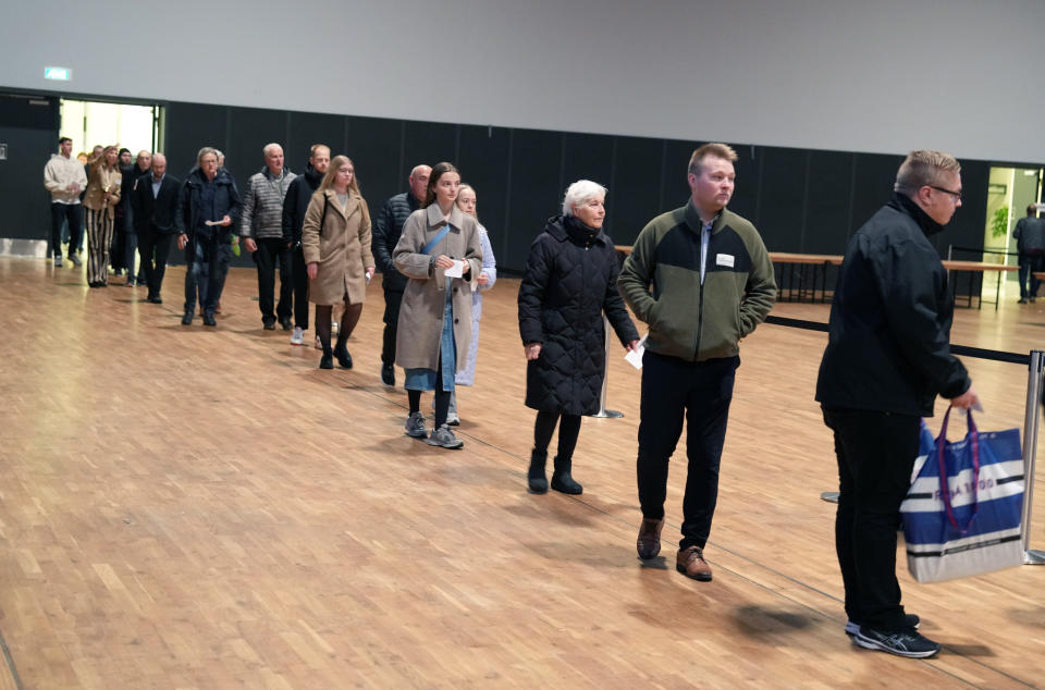 People queue up to cast their ballots for the general election at a polling station in Odense Town Hall, Denmark, Tuesday Nov. 1, 2022. Denmark's election is expected to change its political landscape, with new parties hoping to enter parliament and others seeing their support dwindle. (Henning Bagger/Ritzau Scanpix via AP)