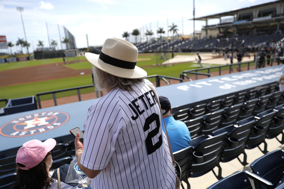 Una mujer con camiseta de Derek Jeter observa el juego de exhibición de los Yanquis de Nueva York y los Nacionales de Washington mientras las Grandes Ligas se prepara para anunciar la cancelación de la pretemporada y posiblemente posponer el inicio de la campaña regular indicaron a The Associated Press personas con conocimiento de las conversaciones el jueves 12 de marzo del 2020. (AP Photo/Julio Cortez)