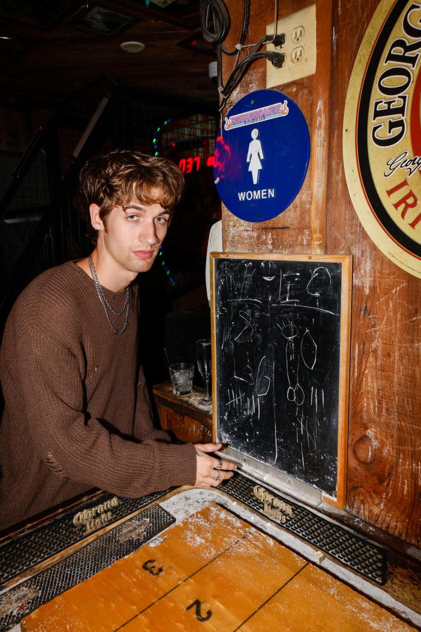 A young person poses by a shuffleboard table at Barney's.