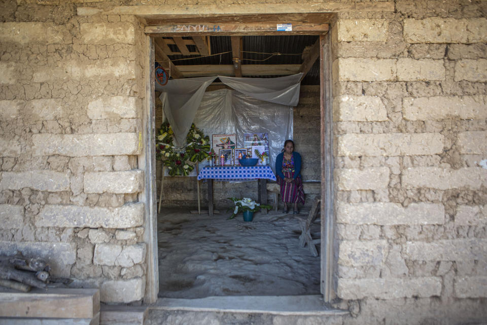 Natalia Tomas keeps vigil next to an altar adorned with photos of her son Ivan Gudiel, in her home in Comitancillo, Guatemala, Wednesday, Jan. 27, 2021. She believes that her son is one of the charred corpses found in a northern Mexico border state on Saturday. The country's Foreign Ministry said it was collecting DNA samples from a dozen relatives to see if there was a match with any of the bodies. (AP Photo/Oliver de Ros)