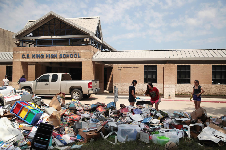 Volunteers place water damaged school furniture and text books&nbsp;on the front lawn of&nbsp;C.E. King High School.