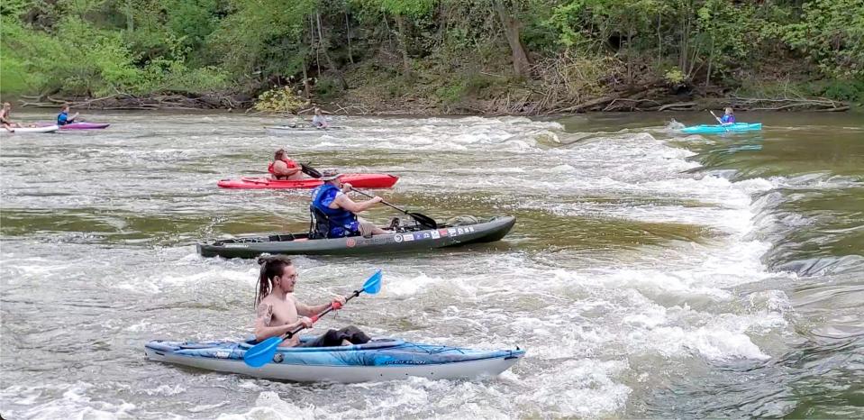 Kayakers arrive at Brinkhaven Saturday, May 13, at the end of the first annual Bill Conrad Memorial Float. Paddler at the upper right prepares to go through the chiseled out section of the old dam while others play in the standing waves.