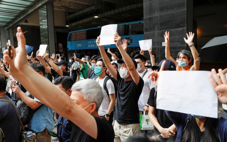 Protesters earlier this month in Hong Kong raise blank paper to highlight the curtailment of free speech under China's new national security law - Tyrone Siu/REUTERS