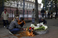 People light candles for the victims near the Vladislav Ribnikar school in Belgrade, Serbia, Wednesday, May 3, 2023. A 13-year-old who opened fire Wednesday at his school in Serbia's capital drew sketches of classrooms and made a list of people he intended to target in a meticulously planned attack, police said. He killed eight fellow students and a guard before calling the police and being arrested. (AP Photo/Armin Durgut)