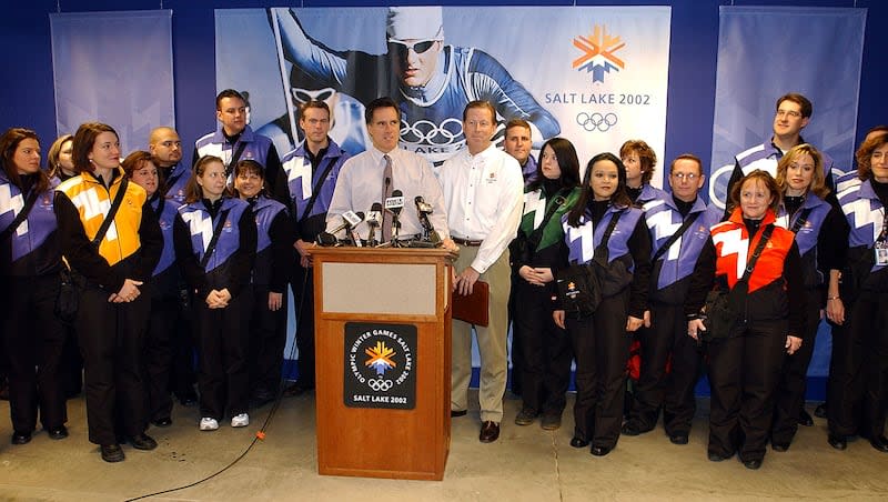 Olympic volunteers join SLOC President and CEO Mitt Romney and Senior Vice President Ed Eynon at a ribbon-cutting to open the Team Processing Center on Dec. 11, 2001.