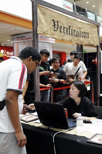 A gamer gets his verification ticket for a newly released copy of Diablo III, the latest edition of one of the biggest videogame franchises of all time, at a computer mall in Singapore on May 15, 2012on May 15, 2012. Thousands of people were waiting outside the mall, many of them taking time off from work or school to grab their copies. (AFP Photo/Simin Wang)