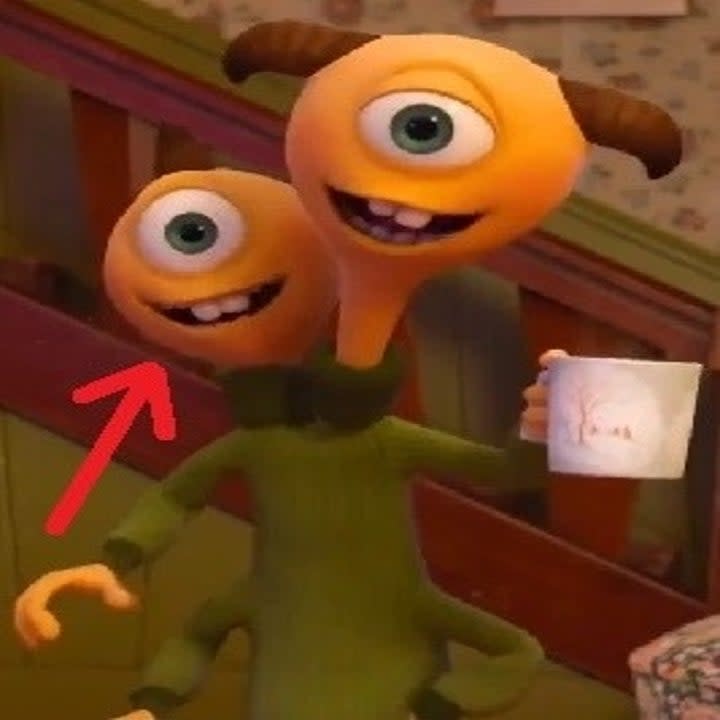 A two headed monster, Terri with an i and Terry with a y from Disney Pixar's Monsters University. There is an arrow pointing to Terri with an i, on the left, and both of them are smiling.