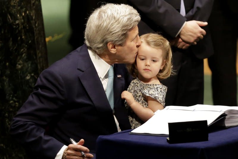 Secretary of State John Kerry kisses his granddaughter, Isabelle Dobbs Higginson, after he signs the Paris Agreement on climate change at the headquarters of the United Nations in New York City on April 22, 2016. File Photo by John Angelillo/UPI