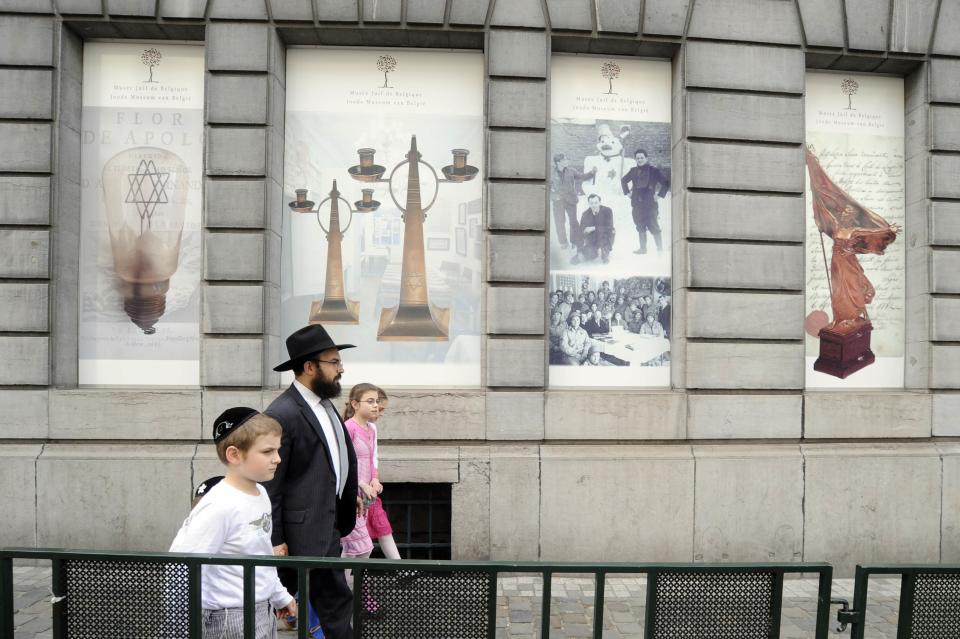 A family walks in front of the Jewish Museum, site of a shooting in central Brussels