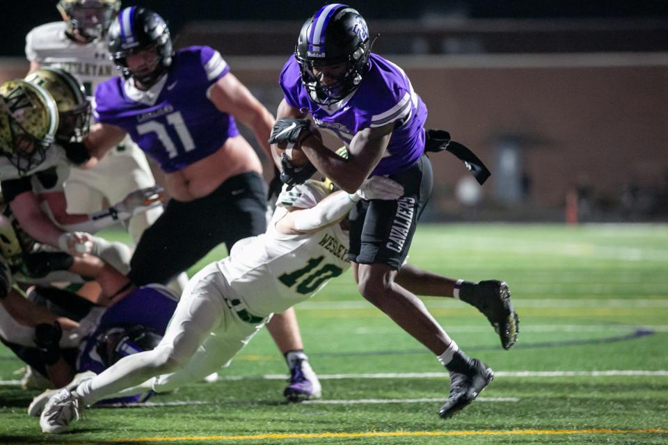 Calvary Day’s running back Trevor Strowbridge breaks through Wesleyan defenders to score a touchdown.