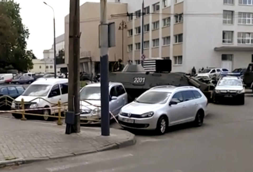 In this image take from video, the scene as streets are closed off, with an armoured security vehicle and police car, right, after an armed man seized a bus and took some 20 people hostage in the city centre of Lutsk, some 400 kilometers (250 miles) west of Kyiv, Ukraine on Tuesday July 21, 2020. The assailant is armed and carrying explosives, according to a Facebook statement by Ukrainian police. Police officers are trying to get in touch with the man and they have sealed off the area. (AP Photo)