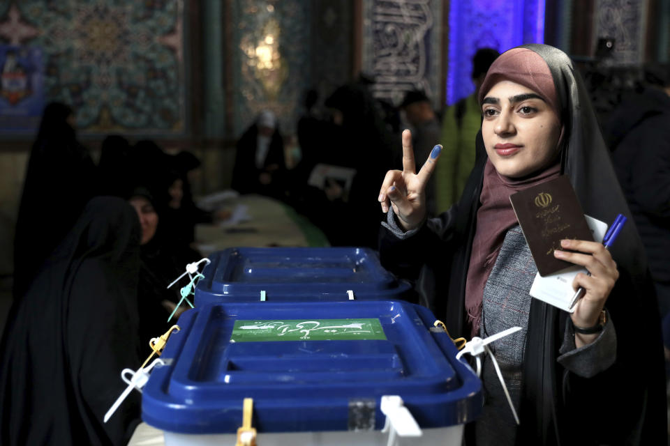 A voter flashes a victory sign with her inked finger while voting for the parliamentary elections at a polling station in Tehran, Iran, Friday, Feb. 21, 2020. Iranians began voting for a new parliament Friday, with turnout seen as a key measure of support for Iran's leadership as sanctions weigh on the economy and isolate the country diplomatically. (AP Photo/Ebrahim Noroozi)