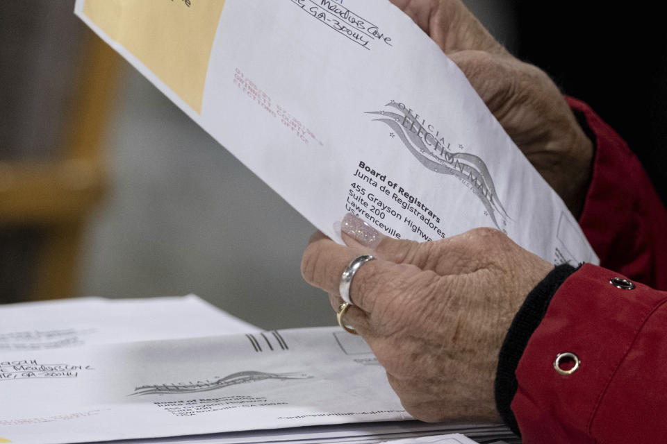 Workers at the Gwinnett County Georgia elections headquarters process absentee ballots for Georgia's Senate runoff election in Lawrenceville, Ga. on Wednesday, Jan. 6, 2021. (AP Photo/Ben Gray)