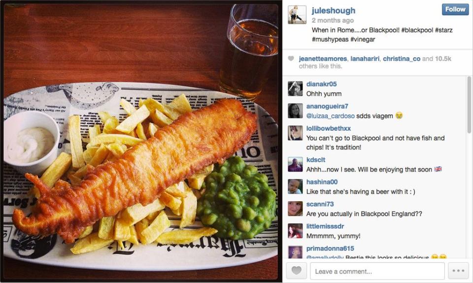 The dancer munches on some fish and chips.