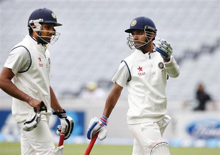 Ajinkya Rahane (R) and Rohit Sharma (L) chat as they leave the field due to bad light on day two of the first international test cricket match against New Zealand, at Eden Park in Auckland February 7, 2014. REUTERS/Nigel Marple