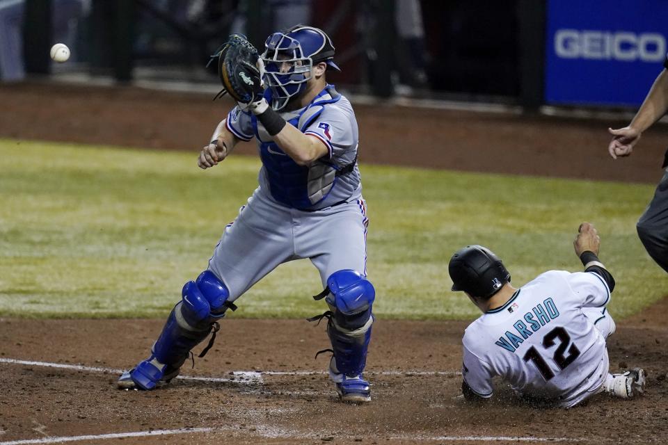 Arizona Diamondbacks' Daulton Varsho (12) scores as Texas Rangers catcher Sam Huff waits for a late throw during the fifth inning of a baseball game Tuesday, Sept. 22, 2020, in Phoenix. (AP Photo/Ross D. Franklin)