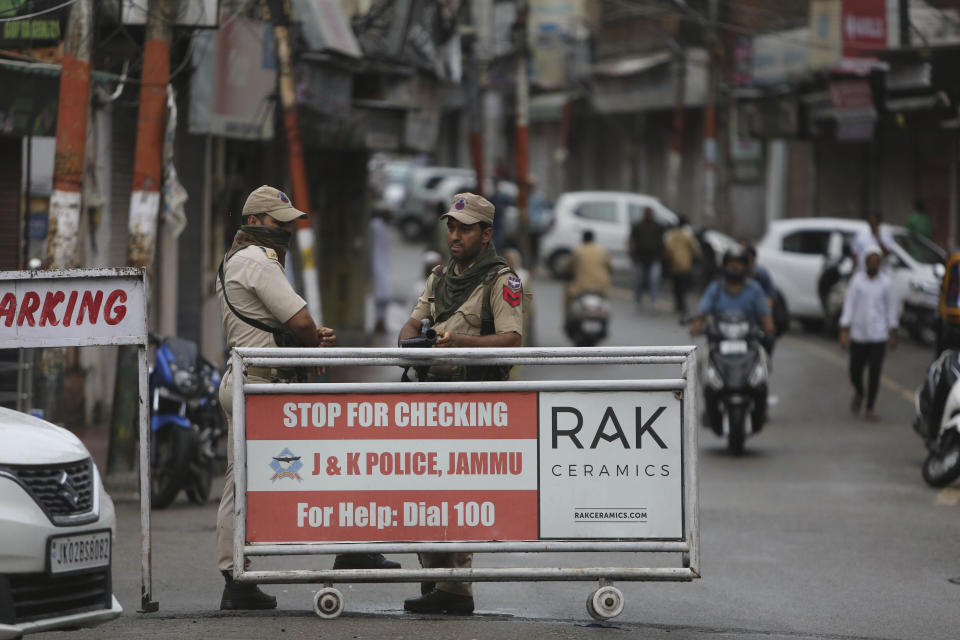 Paramilitary soldiers stand guard near a barricade in Jammu, India, Friday, Aug. 9, 2019. The restrictions on public movement throughout Kashmir have forced people to stay indoors and closed shops and even clinics. All communications and the internet have been cut off. Prime Minister Modi said late Thursday the situation in the region would return to normal gradually. (AP Photo/Channi Anand)