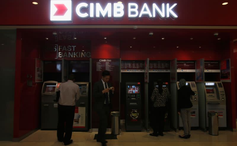 Customers use cash machines at a branch of Malaysia's CIMB Bank in Kuala Lumpur