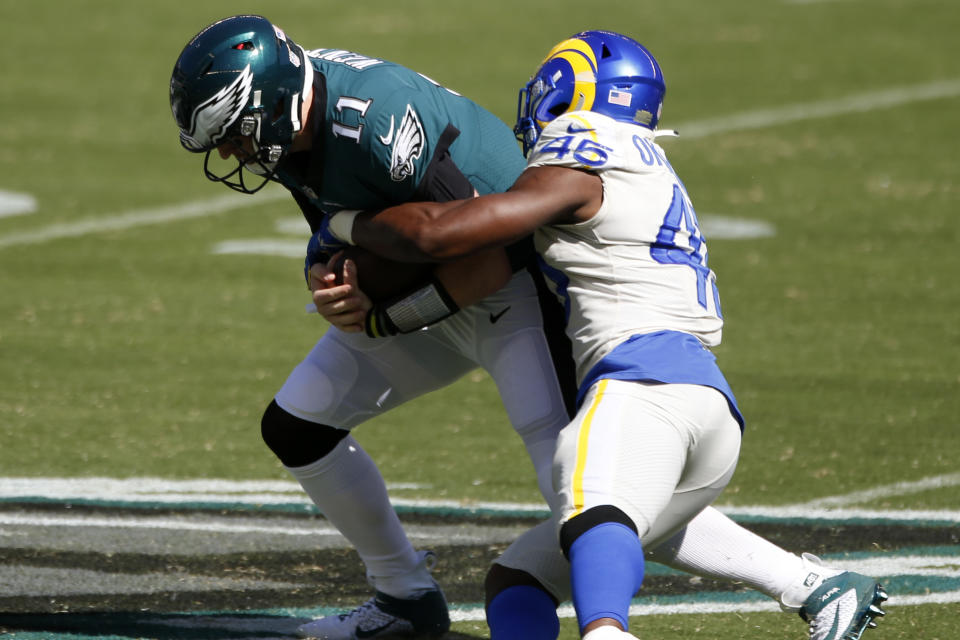 Philadelphia Eagles' Carson Wentz, left, is tackled by Los Angeles Rams' Obo Okoronkwo during the first half of an NFL football game, Sunday, Sept. 20, 2020, in Philadelphia. (AP Photo/Laurence Kesterson)