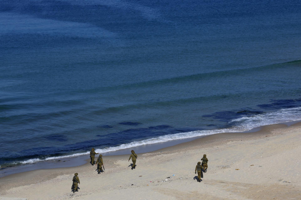 Palestinian militants patrol on the beach of the Mediterranean sea during a military drill organized by military factions outside Gaza City, Tuesday, Dec. 29, 2020. Palestinian militants in the Gaza Strip fired a salvo of rockets into the Mediterranean Sea on Tuesday as part of a self-styled military drill aimed at preparing for a possible war with Israel. (AP Photo/Adel Hana)