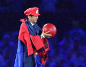 FILE - In this Aug. 21, 2016, file photo, Japanese Prime Minister Shinzo Abe appears as the Nintendo game character Super Mario during the closing ceremony at the 2016 Summer Olympics in Rio de Janeiro, Brazil. Prime Minister Abe might be the biggest loser if the Tokyo Olympics don't go off as planned in just over four months. Abe has attached himself to the success of the Olympics since pushing hard for Tokyo's selection at an IOC meeting in 2013 in Buenos Aires, Argentina. Tokyo was picked over Istanbul by billing itself as a “safe pair of hands." (Yu Nakajima/Kyodo News via AP, File)