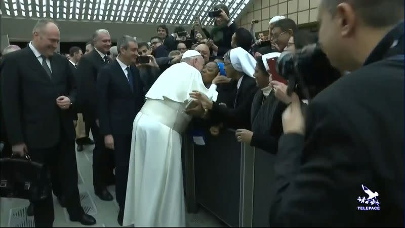 Pope Francis kisses a nun on the cheek after making a joke to her saying "You bite! I will give you a kiss but you stay calm. Don't bite!" as he arrives for the general audience at the Vatican