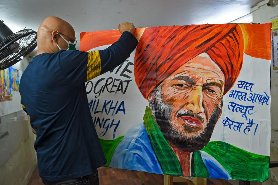 An art teacher holds a painting of Indian track legend Milkha Singh, who overcame childhood tragedy to seek Olympic glory, after he died aged 91 following a long battle with Covid-19 to pay him tribute, at his studio in Mumbai on June 19, 2021. (Photo by Punit PARANJPE / AFP) (Photo by PUNIT PARANJPE/AFP via Getty Images)