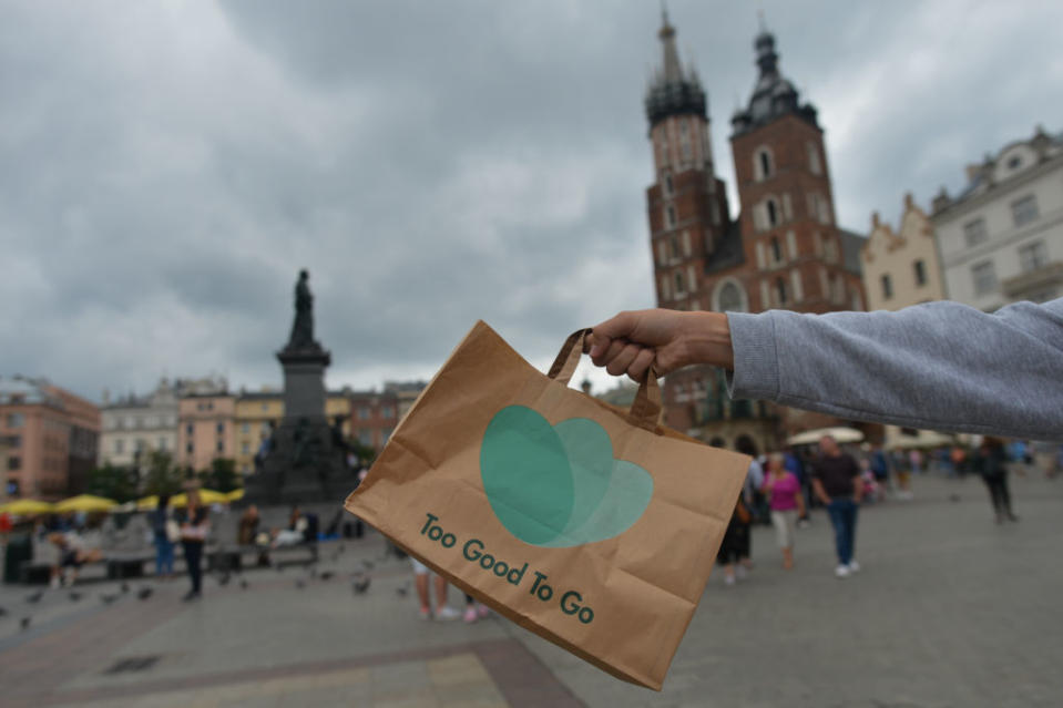 A man carries Too Good To Go bag with food in Krakow's Main Market Square. Too Good To Go allows local food stores, cafes and restaurants to sign up and post the left-over meals that they have at the end of the day and the discounted price they want for them. Too Good To Go (TGTG) is worldâs number 1 app for fighting food waste. On Wednesday, August 11, 2019, in Krakow, Poland. (Photo by Artur Widak/NurPhoto)