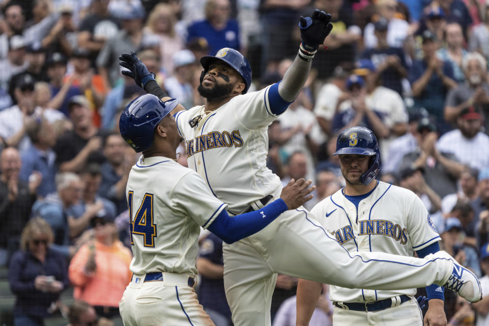 Seattle Mariners' Carlos Santana celebrates with Julio Rodriguez after hitting a three-run home run off San Diego Padres starting pitcher Mike Clevinger during the fifth inning of a baseball game, Wednesday, Sept. 14, 2022, in Seattle. (AP Photo/Stephen Brashear)