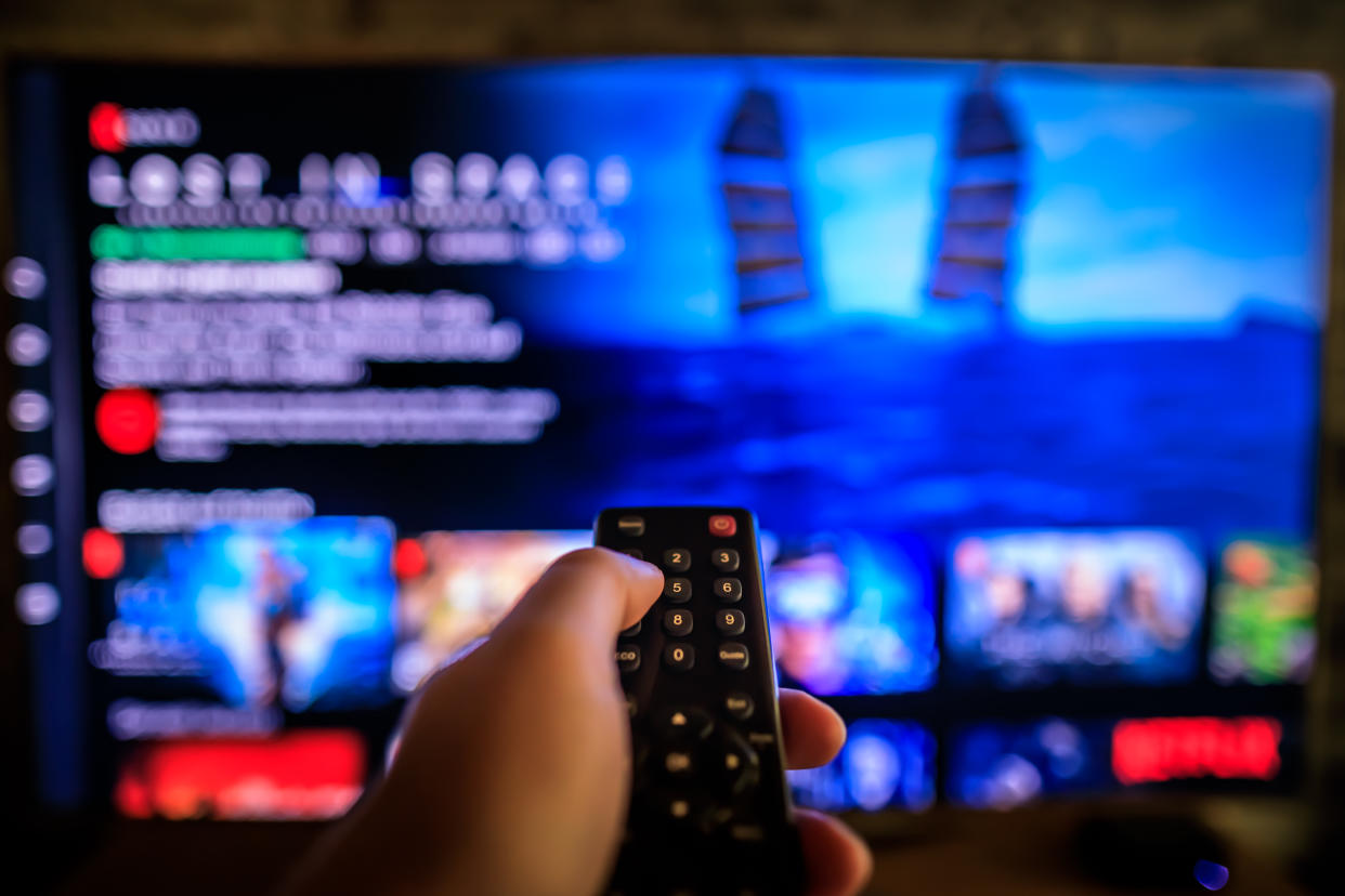 These Amazon Prime Day TV deals are too good to pass up. TV remote control in the foreground, Video on demand screen in the blurry background, streaming