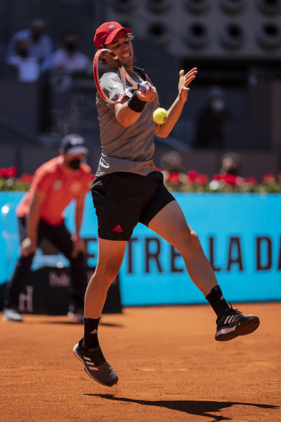 Austria's Dominic Thiem returns the ball to United States' John Isner during their match at the Mutua Madrid Open tennis tournament in Madrid, Spain, Friday, May 7, 2021. (AP Photo/Bernat Armangue)