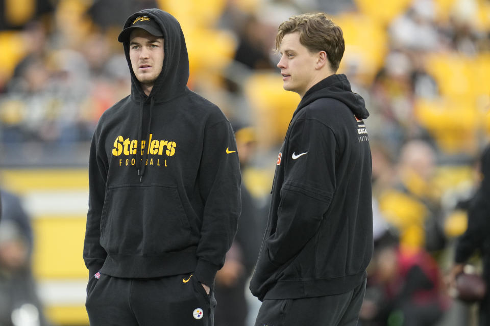 Pittsburgh Steelers quarterback Kenny Pickett, left, and Cincinnati Bengals quarterback Joe Burrow watch warmups together before the start of an NFL football game, Saturday, Dec. 23, 2023, in Pittsburgh. (AP Photo/Gene J. Puskar)