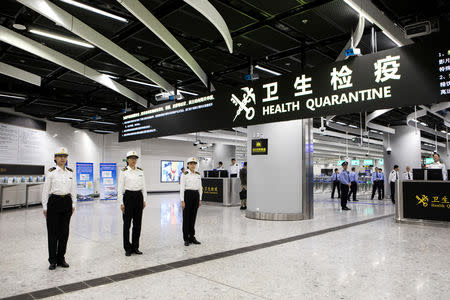 Officers stand under a sign reading "Health Quarantine" in the Mainland Port Area at West Kowloon Station, which houses the terminal for the Guangzhou-Shenzhen-Hong Kong Express Rail Link (XRL), developed by MTR Corp., in Hong Kong, China, September 22, 2018. Giulia Marchi/Pool via REUTERS