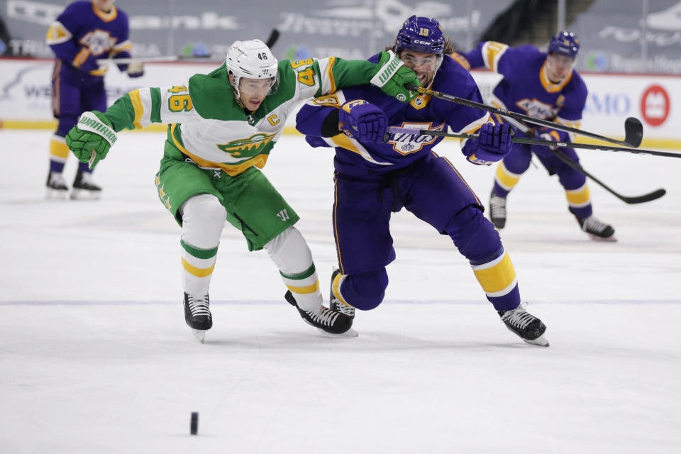 Los Angeles Kings right wing Alex Iafallo (19) and Minnesota Wild defenseman Jared Spurgeon (46) battle for the puck in the first period during an NHL hockey game, Saturday, Feb. 27, 2021, in St. Paul, Minn. (AP Photo/Andy Clayton-King)