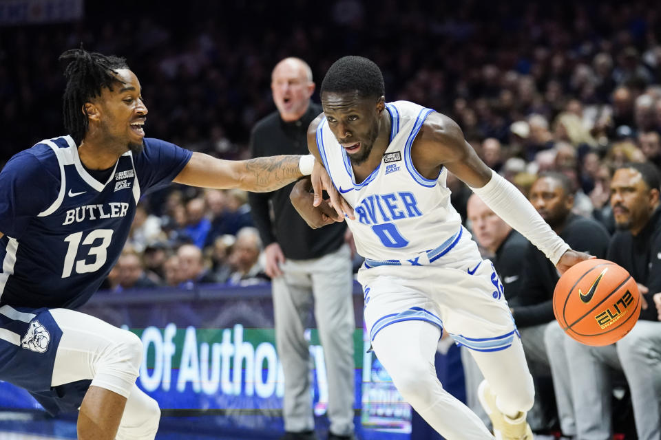 Xavier guard Souley Boum (0) dribbles as Butler guard Jayden Taylor (13) defends during the first half of an NCAA college basketball game, Saturday, March 4, 2023, in Cincinnati. (AP Photo/Joshua A. Bickel)