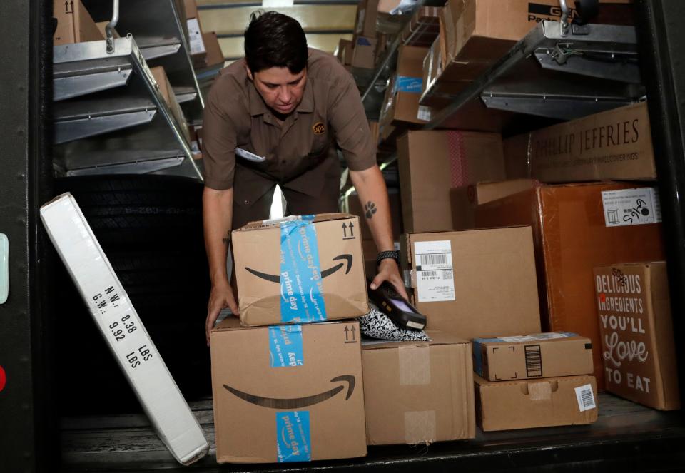 In this July 17, 2018, file photo UPS employee Liz Perez unloads packages for delivery in Miami.