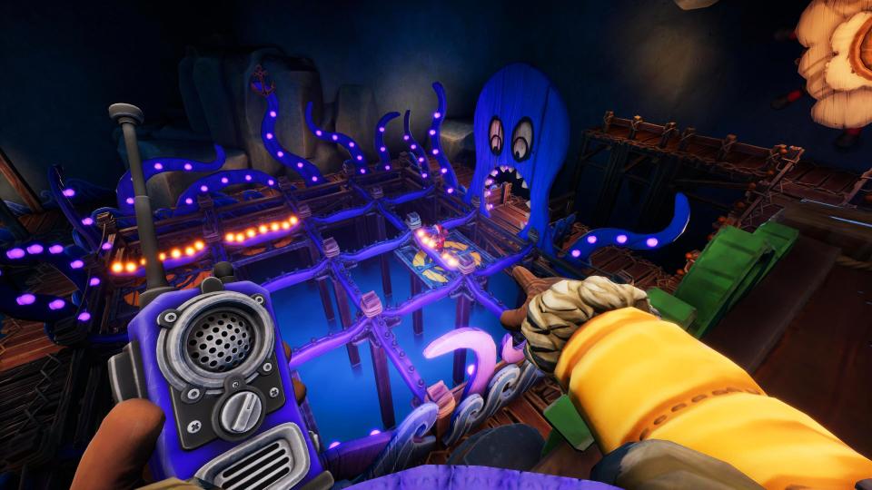 We Were Here Expeditions: The Friendship - a player holding a walkie talkie points to their partner who is below, controlling a platform in a carnival ride