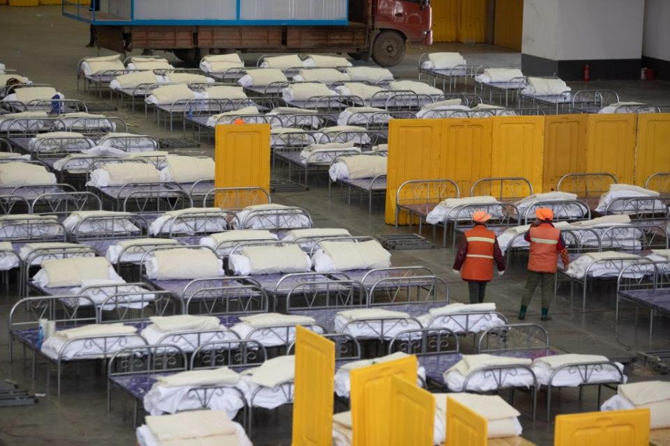 Workers lay beds in the Wuhan living room exhibition center, Wuhan, Hubei Province, China, February 4, 2020.