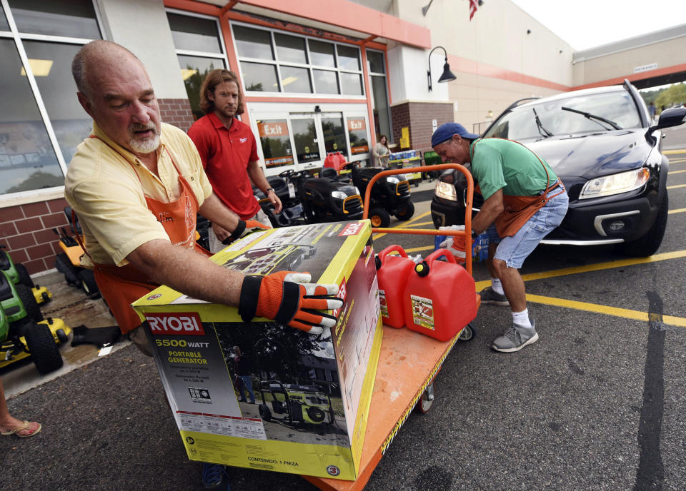 Jim Craig, David Burke and Chris Rayner load generators as people buy supplies at The Home Depot on Monday, Sept. 10, 2018, in Wilmington, N.C. Hurricane Florence rapidly strengthened into a potentially catastrophic hurricane on Monday as it closed in on North and South Carolina, carrying winds and water that could wreak havoc over a wide stretch of the eastern United States later this week. (Ken Blevins/The Star-News via AP)