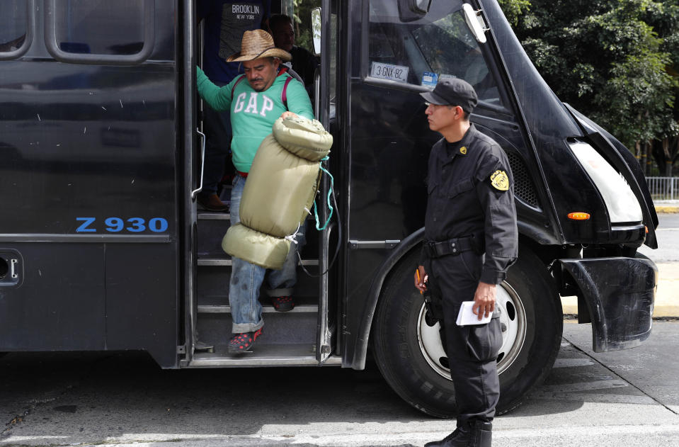 Central American migrants, part of the caravan hoping to reach the U.S. border, disembark from a Guadalajara Municipal Police bus, as they make it to a shelter in Guadalajara, Mexico, Monday, Nov. 12, 2018. Several thousand Central American migrants marked a month on the road Monday as they hitched rides toward the western Mexico city of Guadalajara. (AP Photo/Marco Ugarte)