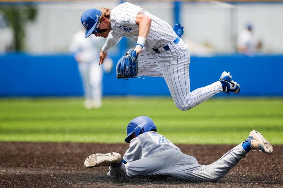 Lexington Catholic Max DeGraff jumps over an Apollo runner at second base during the KHSAA Baseball State Tournament at Counter Clocks Field on Saturday.