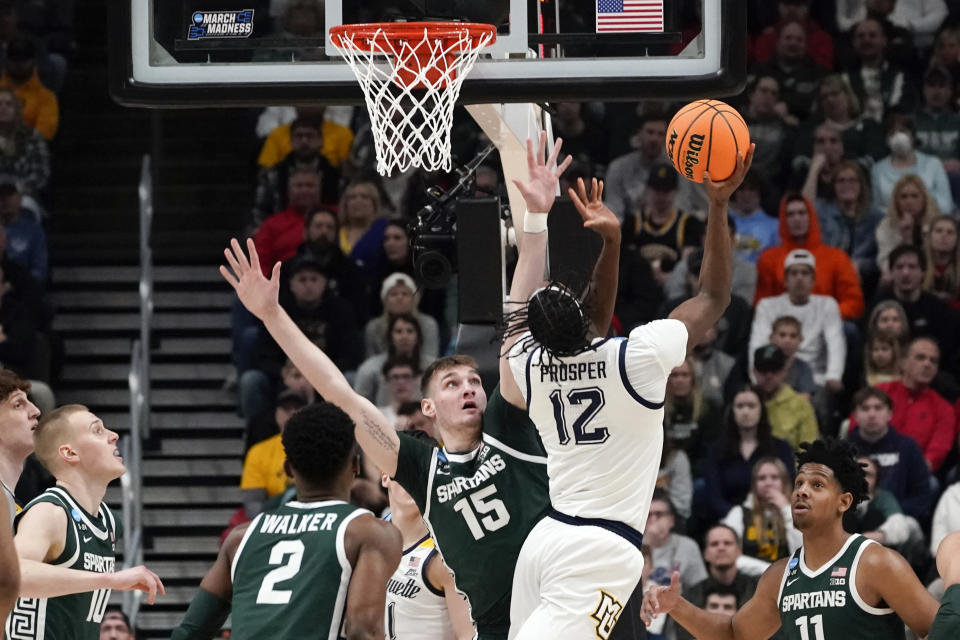 Marquette forward Olivier-Maxence Prosper (12) shoots on Michigan State center Carson Cooper (15) in the first half of a second-round men's college basketball game in the NCAA Tournament Sunday, March 19, 2023, in Columbus, Ohio. (AP Photo/Paul Sancya)