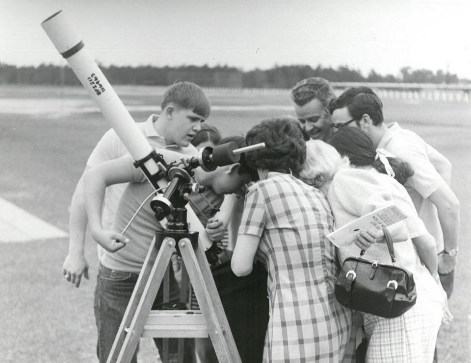 Crowds of solar eclipse watchers gather around a telescope on March 7, 1970.